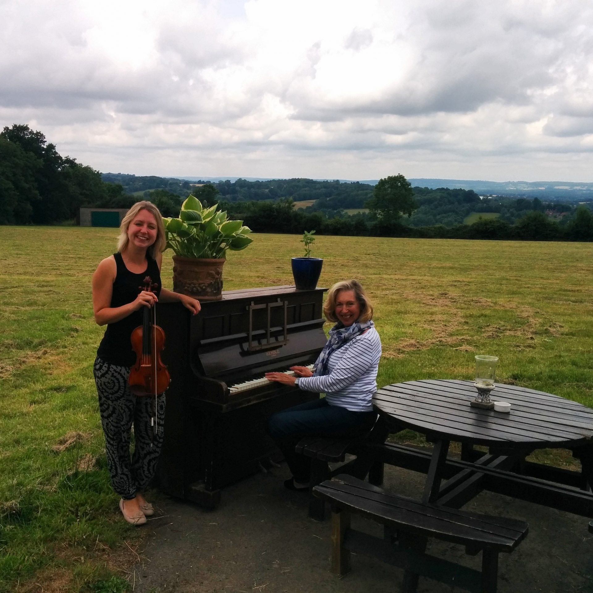 Jennifer and Diane posed at an upright piano, in a field!