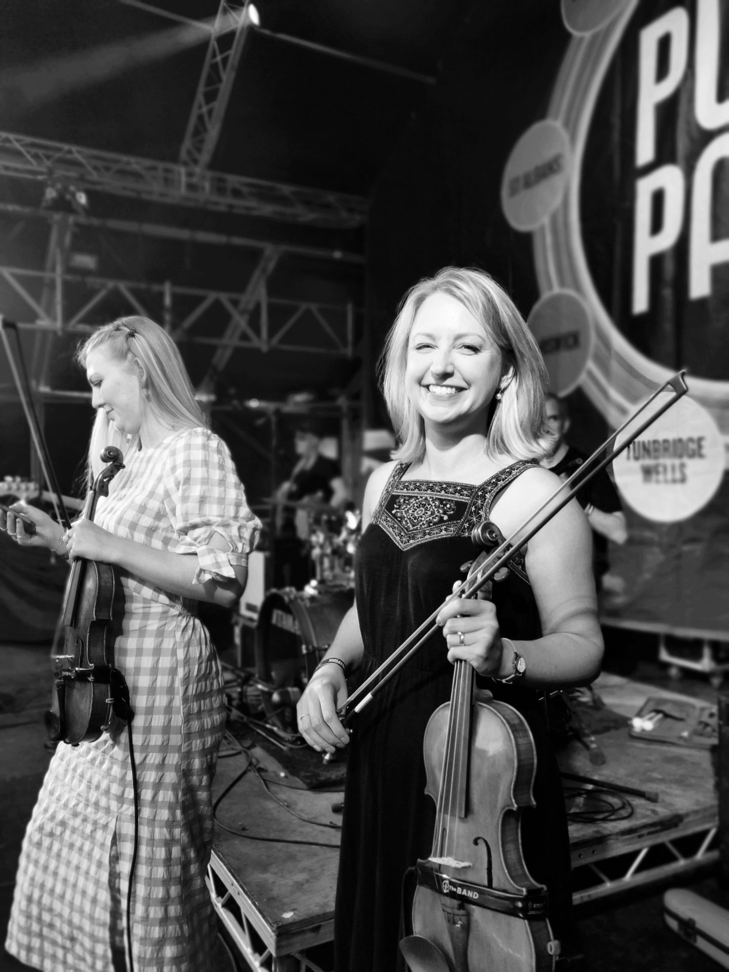 Jennifer holding violin on stage, smiling at Pub in the Park, Chiswick.